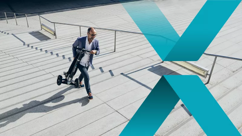 A man walks briskly up the stairs with his XBoard closed. 